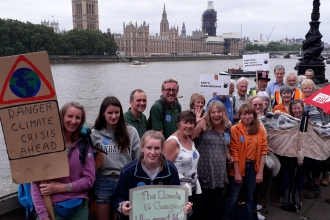 Group with placards with the Thames and Houses of Parliament in the background