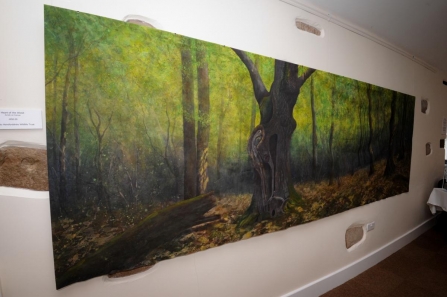 Painting of a woodland hung in a gallery