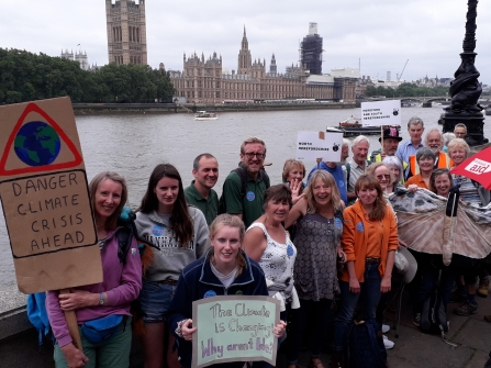 Group with placards with the Thames and Houses of Parliament in the background