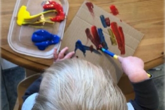 View from above young child's head at child painting