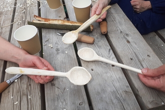 Wooden spoons being help over a table