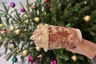 Hot chocolate with cream and marshmallows in festive take away cup