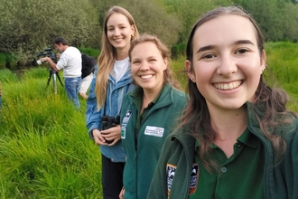 Three women outdoors smiling at camera