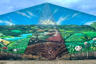 Mural of rural scene painted on end of barn