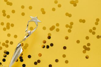 Shiny award in front of golden background