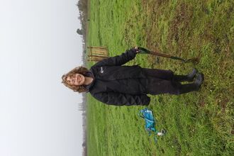 Young woman holding a spade in a field