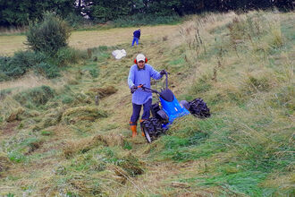 Volunteer mowing sloping bank