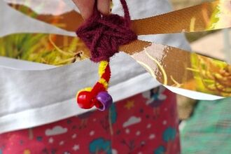 Close up of child's hands with a crafted dragonfly