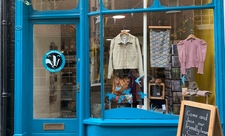 Shop window with blue paintwork and clothes hanging in the window