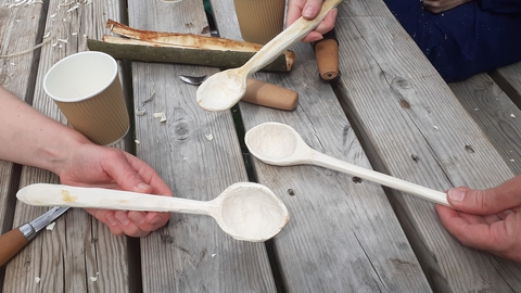 Wooden spoons being help over a table