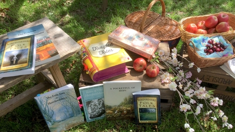 Tangled Tales books scattered in orchard