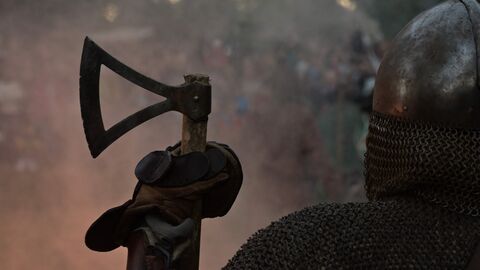 Silhouette profile of a man in armour holding an axe