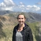 Portrait of young woman stood outdoors with mountains in background