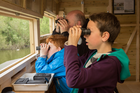 Family birdwatching in hide