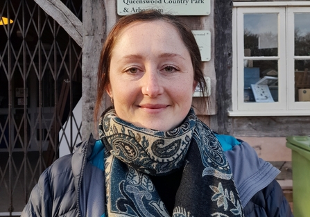 Portrait photo of woman's head and shoulders with brown hair wearing a coat and scarf