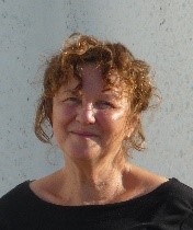 Head and shoulders portrait of woman with curly brown hair smiling