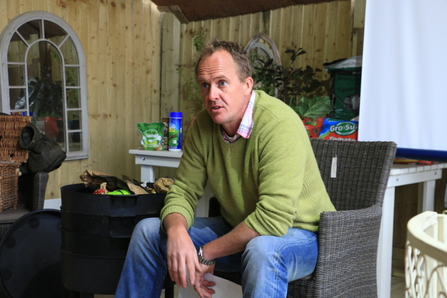 Man sat on a chair in a green jumper