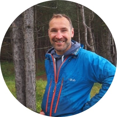 Man wearing blue casual jacket stood in woodland