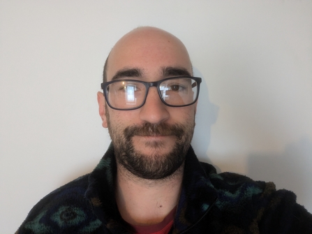 Portrait of man with glasses and short dark beard