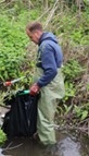 Man wearing waders stood in a stream