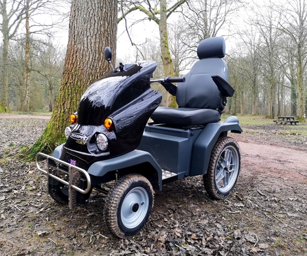 'Tramper' electric mobility vehicle beside a tree in winter woodland