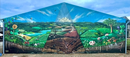 Mural of rural scene painted on end of barn