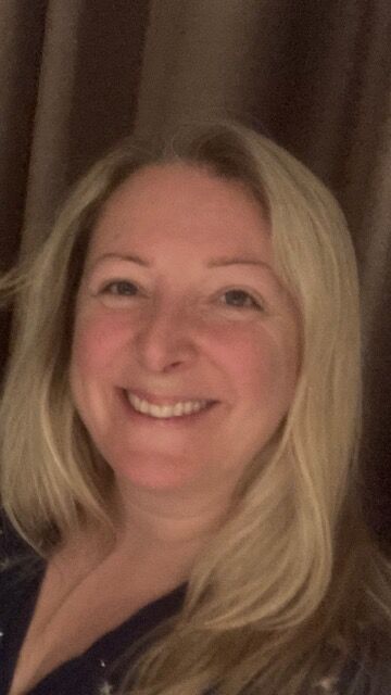 Headshot of woman with long blond hair smiling at the camera