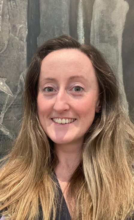Woman with long dark blond hair smiling