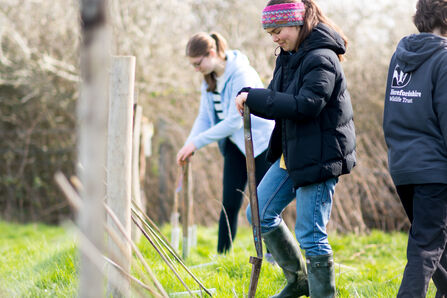 Two young women planting trees