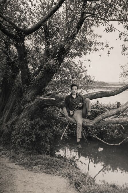 A young man sitting on a tree on the banks of the Canny Brook
