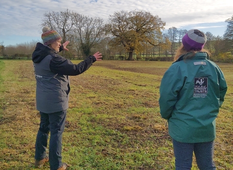 Two women stood in a field talking