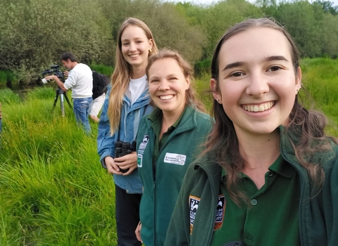Three women outdoors smiling at camera