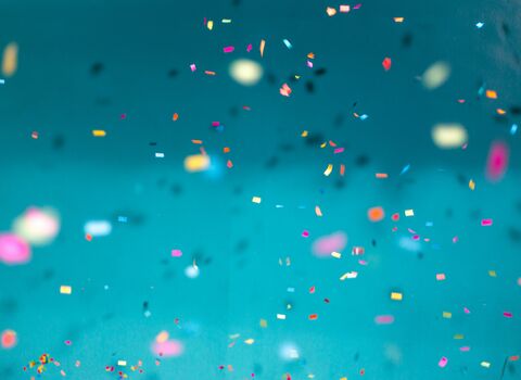 Coloured glitter spots falling in front of blue background